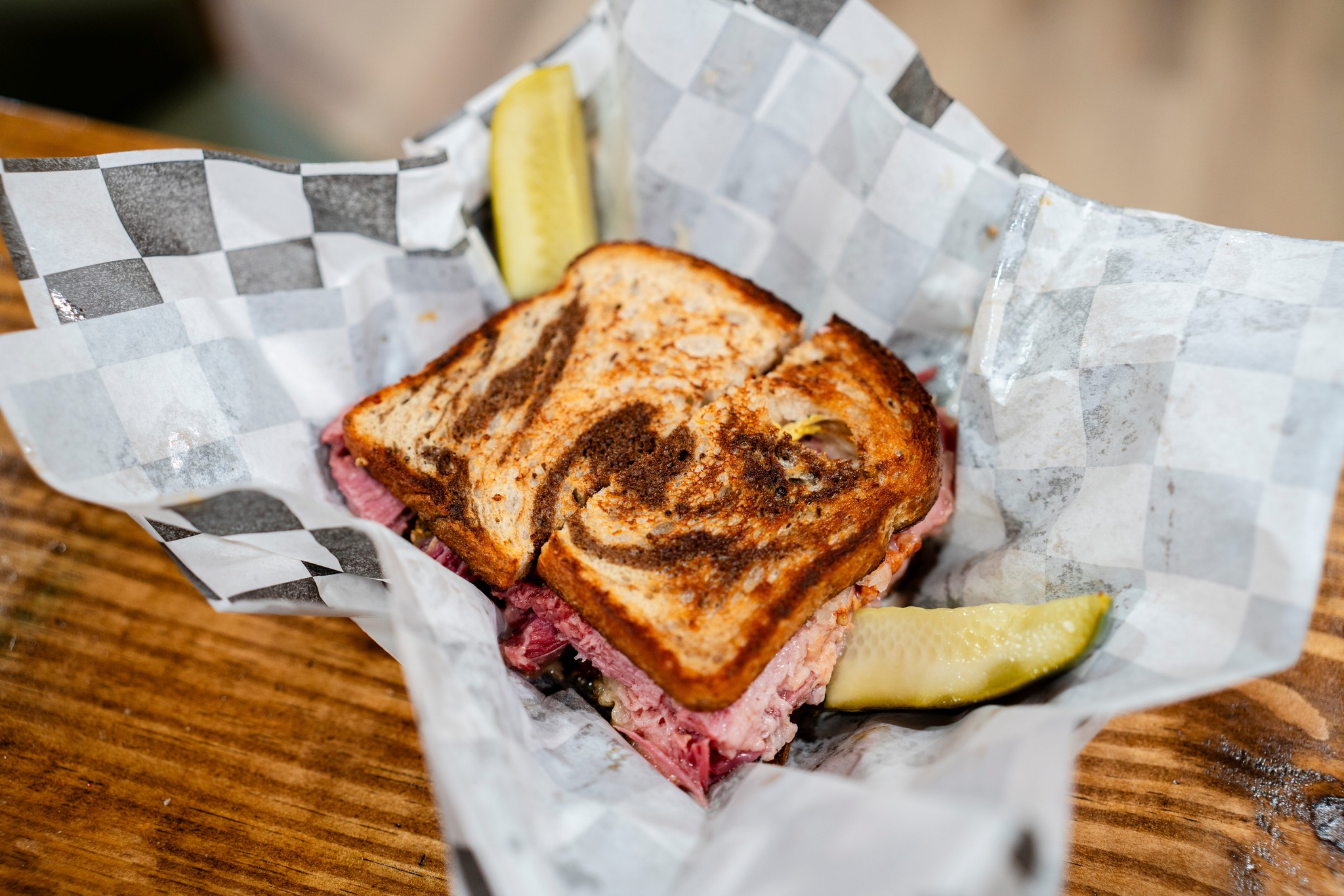 Corned beef sandwich on rye with a pickle spear
